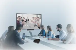 a group of people sitting at a table using a laptop