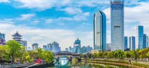 a bridge over a body of water with a city in the background